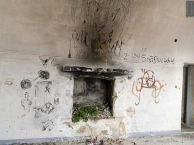In un altro ambiente, sopra un piccolo caminetto murato, troviamo il disegno di un demone avvolto dalle fiamme. E accanto altre incisioni come spade, asce e cerchi neri